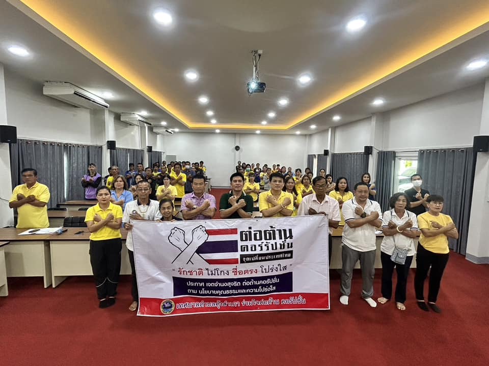 ภาพหมู่เจ้าหน้าที่ยืนถือป้ายต่อต้านคอร์รัปชัน